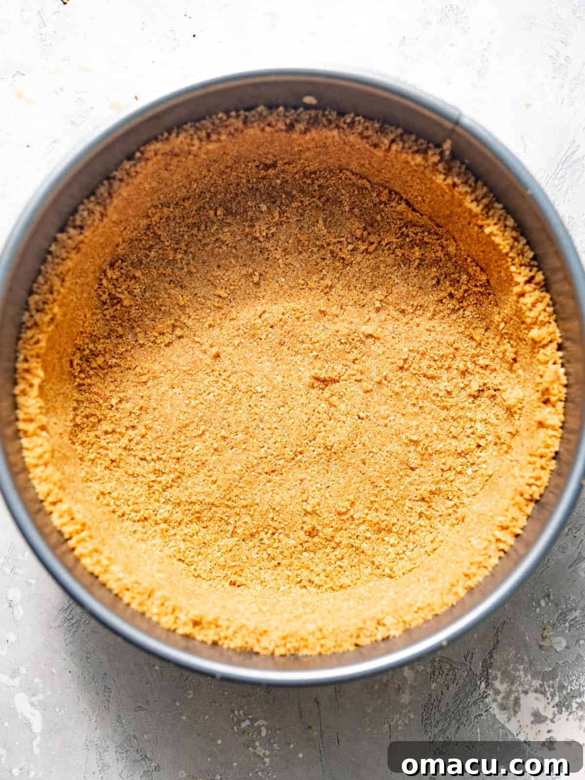 Salted Caramel Peach Cobbler Cheesecake Recipe 6 graham cracker crust in a parchment paper lined springform pan.