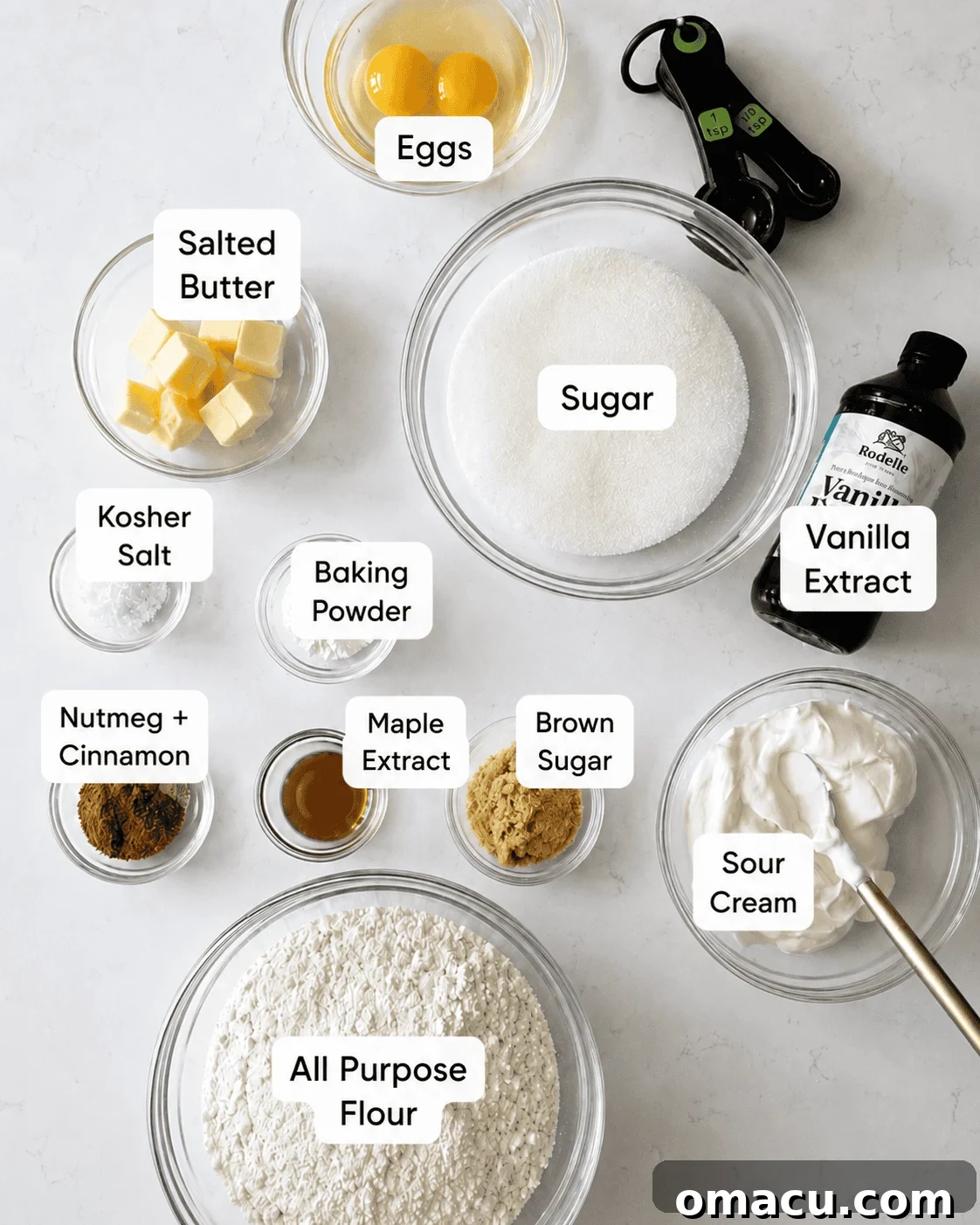 Classic Maple Cake Donuts Recipe 3 Ingredients for maple sour cream donuts arranged in bowls, including all-purpose flour, sour cream, eggs, brown sugar, butter, maple extract, cinnamon, and nutmeg.