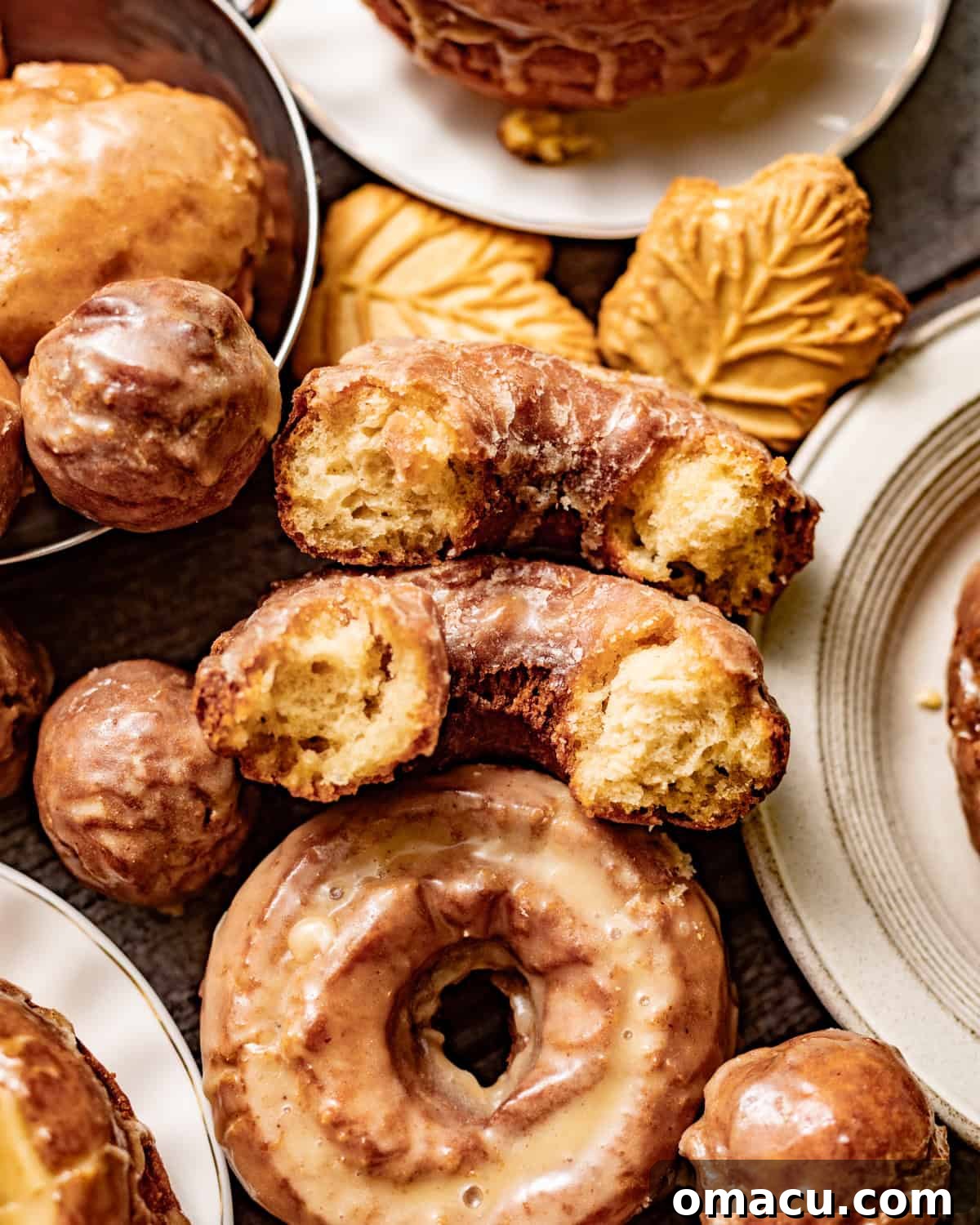 Classic Maple Cake Donuts Recipe 8 Glazed maple donuts with crisp golden edges and a soft, cakey interior, including one donut broken open to show the crumb.
