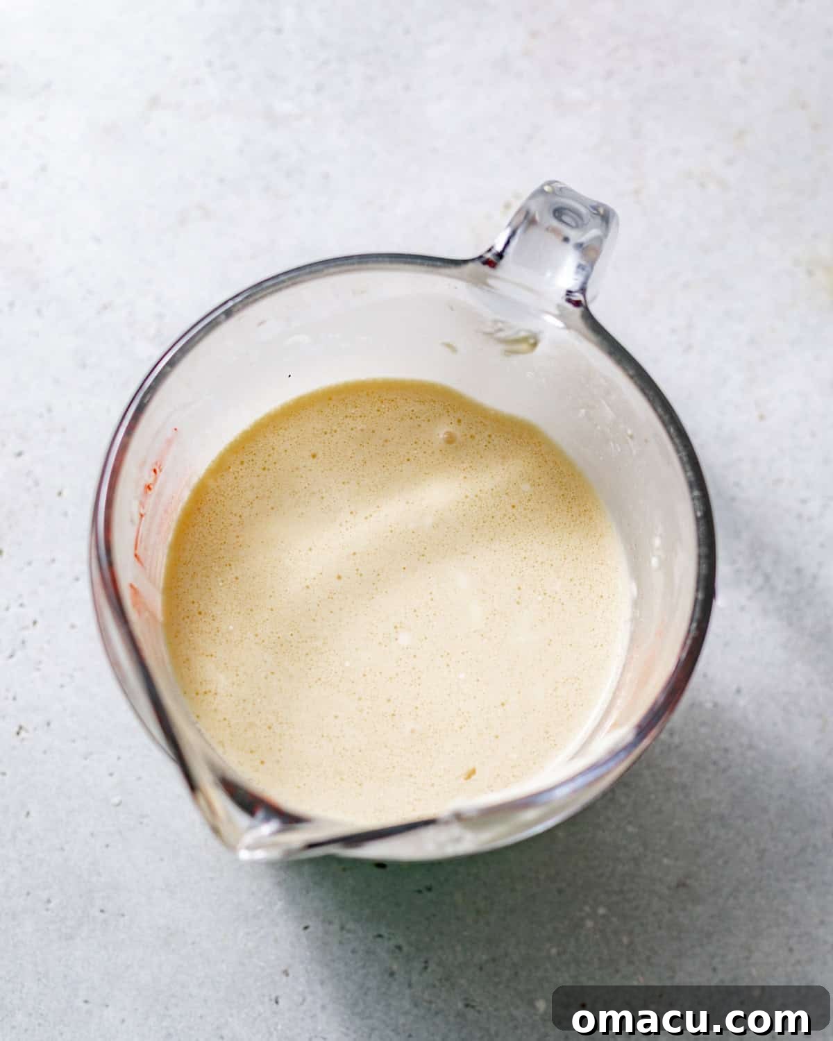 milk cake soak mixed together in a small glass measuring cup.