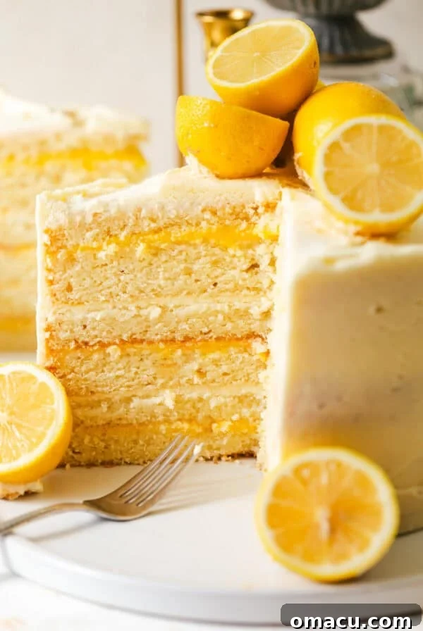lemon layer cake on a cake stand cut to show the inner lemon curd filling.