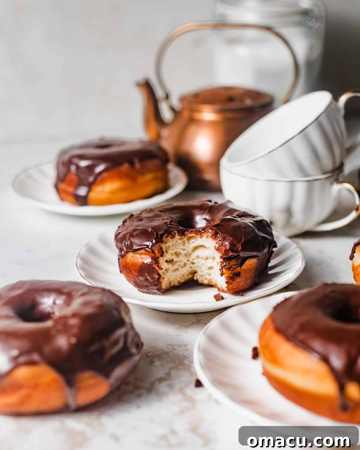 Chocolate glazed yeast donut with a bite taken out, showing the soft, fluffy interior.