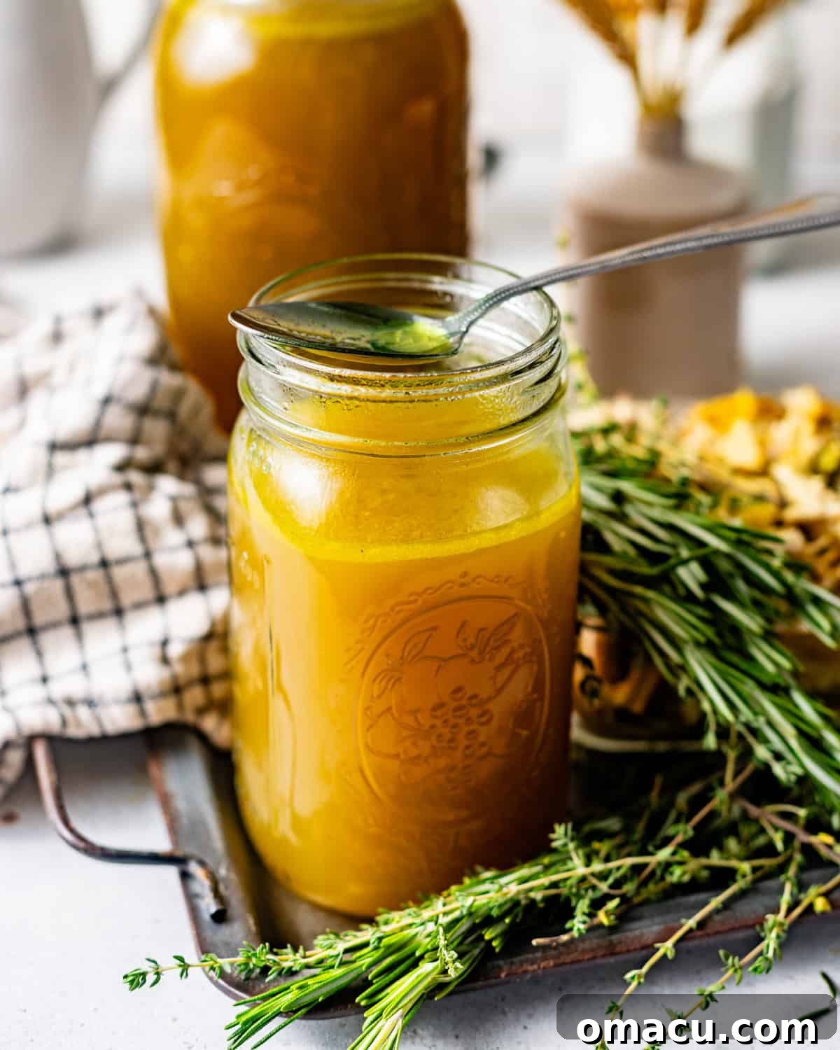 chicken broth in a mason jar with a spoon on top of the jar.