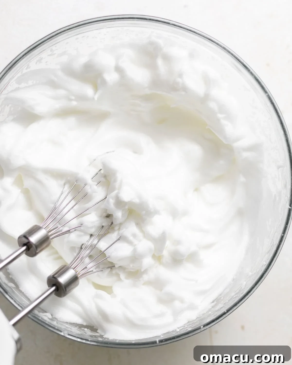 Classic Italian Cream Cake Recipe with Cream Cheese Frosting 7 Egg whites beaten to stiff peaks in a clean glass bowl.