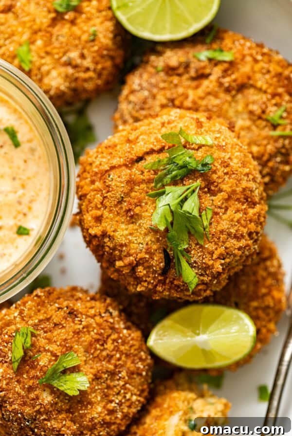 golden salmon croquettes garnished with parsley and served with creole dipping sauce and lime.