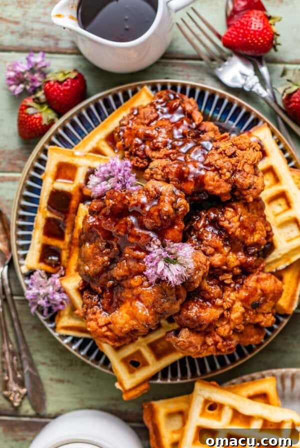 Crispy Southern Fried Green Tomatoes Recipe 13 crispy fried chicken and waffles on a plate topped with maple sriracha and strawberries.