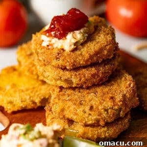 Crispy Southern Fried Green Tomatoes Recipe 14 fried green tomatoes stacked on top of one another with pimento cheese on top.