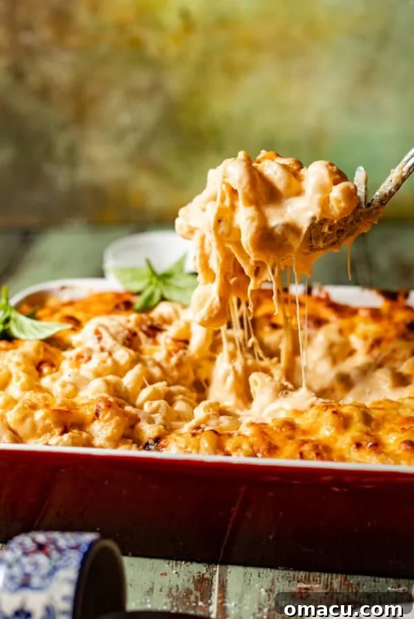 smoked gouda mac and cheese in a pan with a spoon showing the cheese pull.