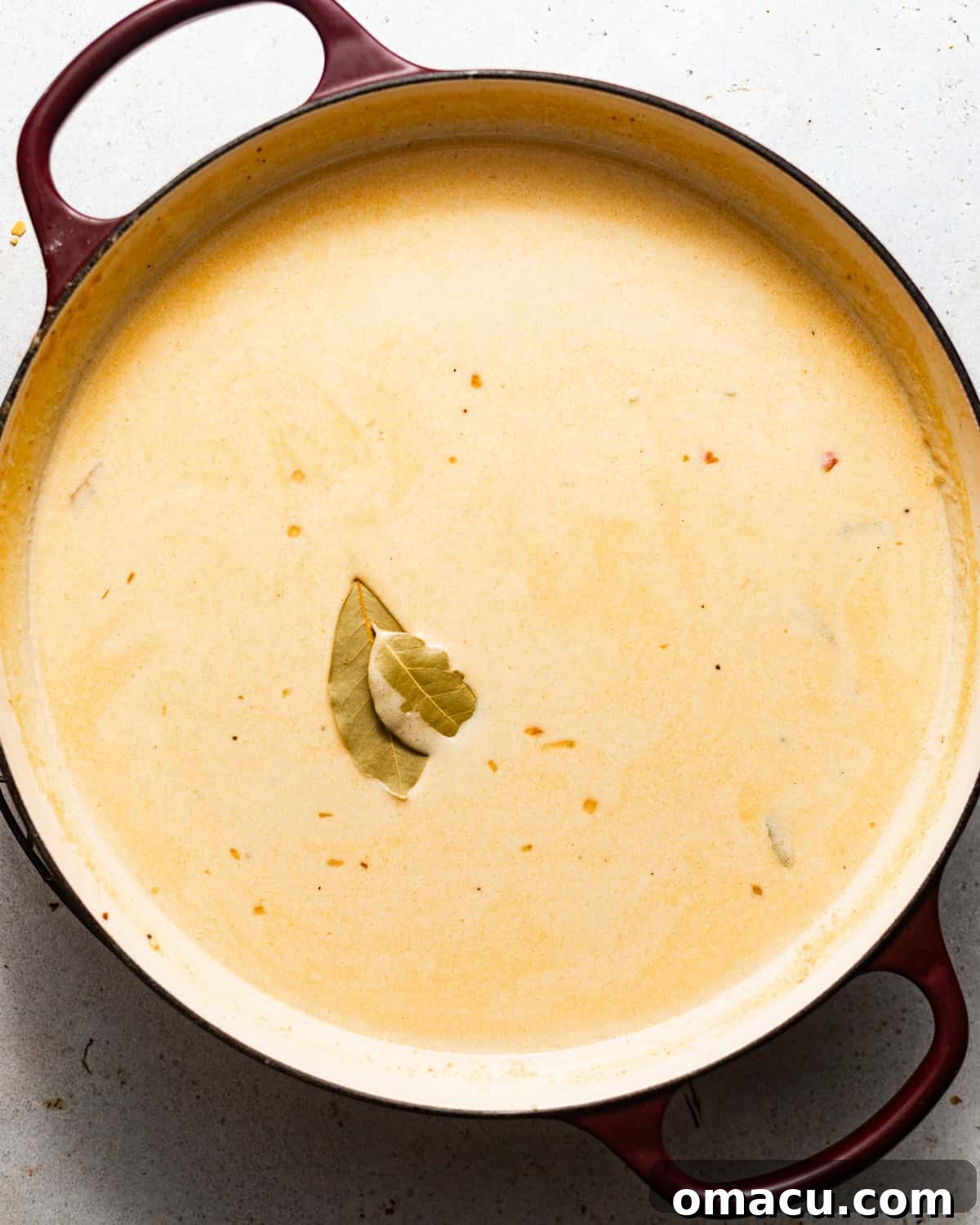 Classic She-Crab Soup: Southern Creamy Crab Recipe 4 she crab soup simmering in a pot with bay leaves.