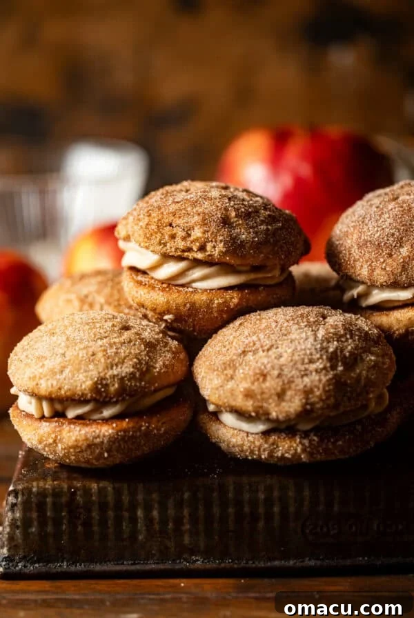 apple cider whoopie pies stacked on top of each other on a serving tray.
